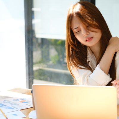Beautiful young asian businesswoman with office syndrome have problem with part of body arm shoulder head neck back healthy problem after working on laptop for a long time.